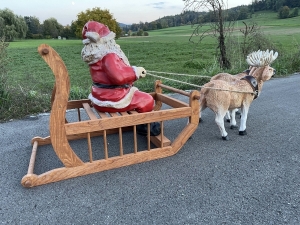 Zwei Rentiere mit Weihnachtsmann Schlitten in Seitenansicht.