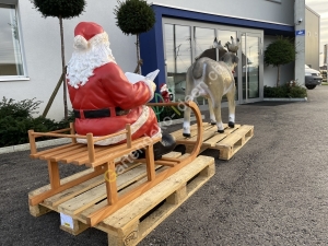 Rentier mit Schlitten und Weihnachtsmann mit Buch lebensgross