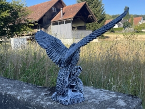 betonfarbene adlerfigur in schraeger ansicht von rechts
