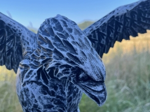 kopfdetail der betonfarbenen adlerfigur mit markantem schnabel