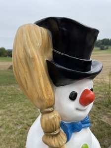 Deko Schneemann mit Zylinderhut und Besen als Kopfdetail.