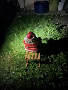Deko Weihnachtsmann mit Schlitten 65 cm in der Gartenansicht.
