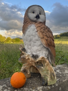 eule als gartenfigur in der frontansicht von unten