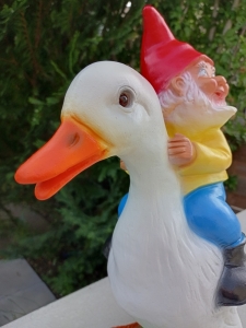 Lustiger Gartenzwerg, der eine Ente reitet 7