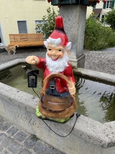 Gartenzwerg mit Korb als Pflanztopf, gut sichtbare Seitenansicht.