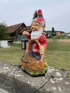 Gartenzwerg mit Laterne und Pflanzkorb als robuste Outdoor-Deko.