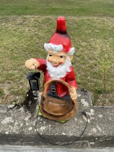 Gartenzwerg XXL mit Pflanzkorb und Laterne aus leicht erhoehter Perspektive.