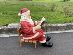 Grosser Weihnachtsmann auf Schlitten mit Buch seitlich.