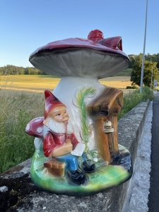 Rot-weisses Pilzhaus mit Zwerg in seitlicher Ansicht