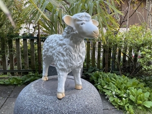 Kleines weisses Schaf als stehende Gartenfigur von der Seite.
