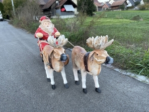 Weihnachtsmann Schlitten mit zwei Rentieren schraeg von vorne.
